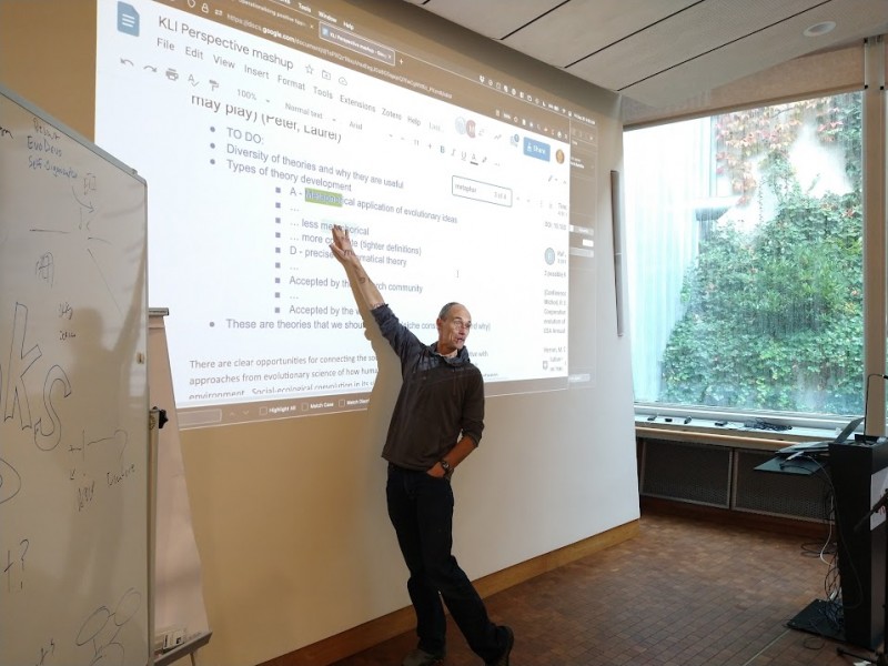 A person pointing to a whiteboardDescription automatically generated with low confidence